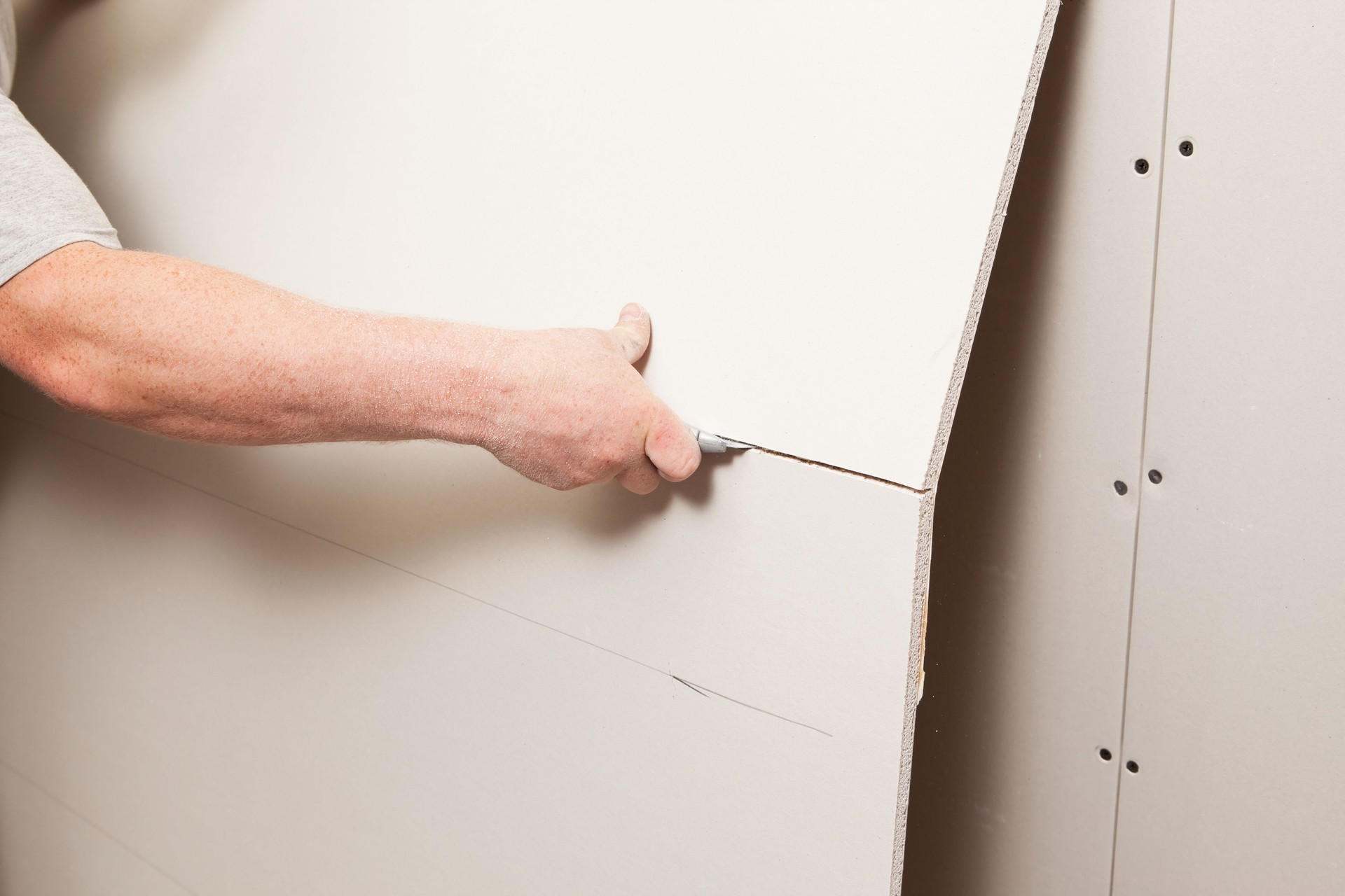 Worker Cutting Drywall with a Utility Knife
